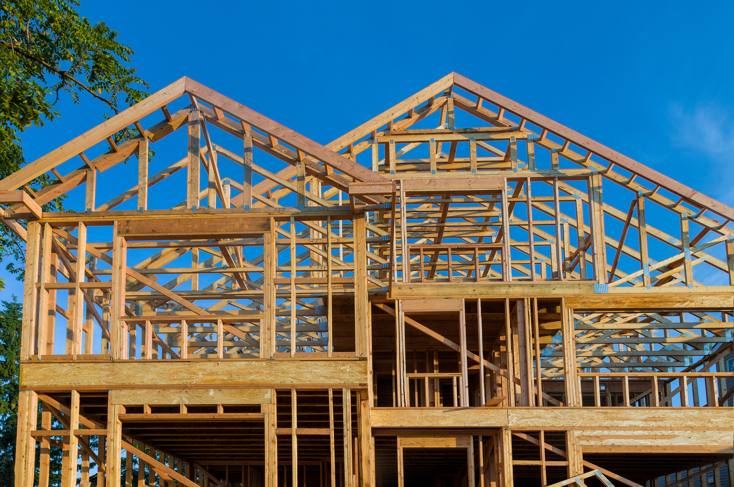 New construction home residential construction home framing against a blue sky